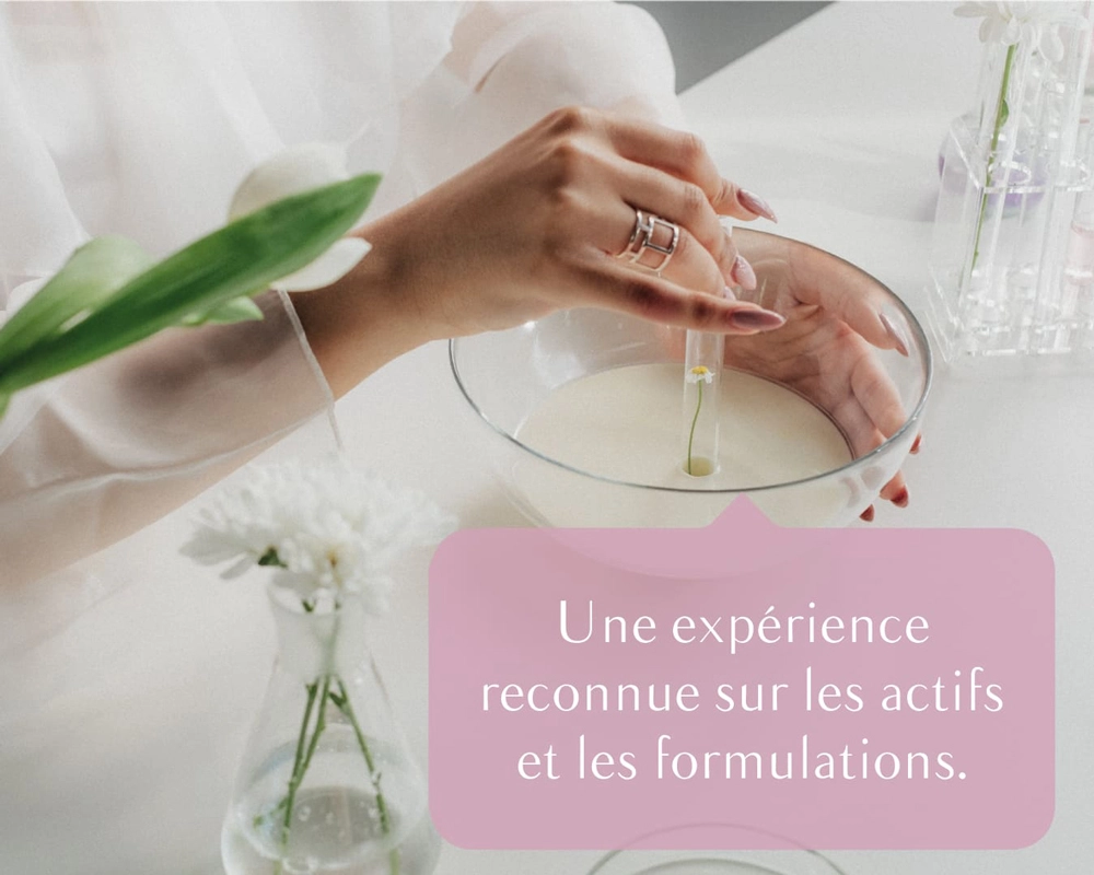 Visuel réseaux sociaux « Une expérience reconnue sur les actifs et les formulations », main plongeant une fleur dans un bol de crème